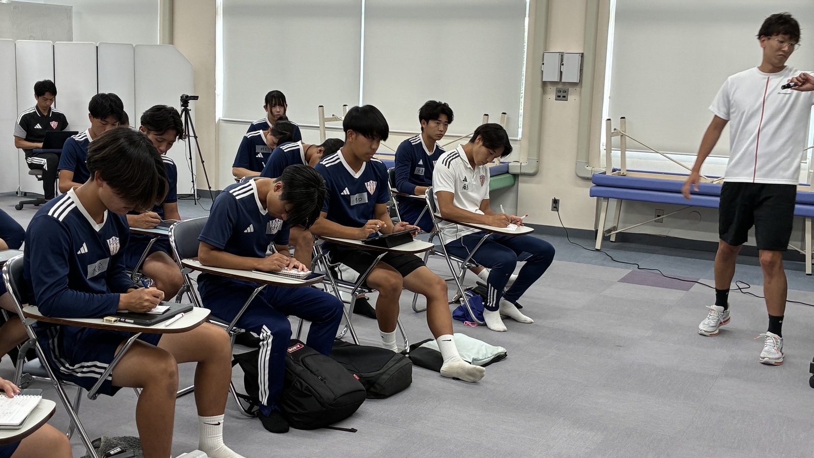 産学連携の特別講義で講師の問いかけを聞き、ノートを取る学生たち