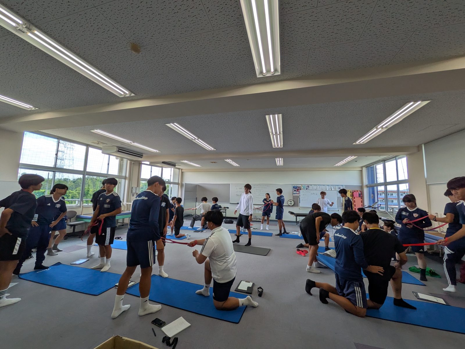 ペアストレッチの実技に取り組むトレーナー志望の学生たち